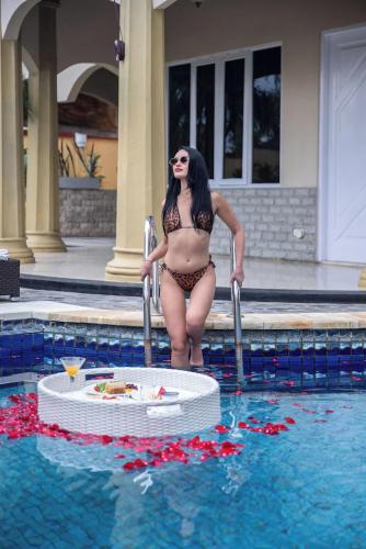 a woman in a bikini standing in a swimming pool at The Beverly Hills Bali Villas Resort in Jimbaran