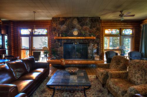a living room with leather furniture and a stone fireplace at Overlander Mountain Lodge in Jasper