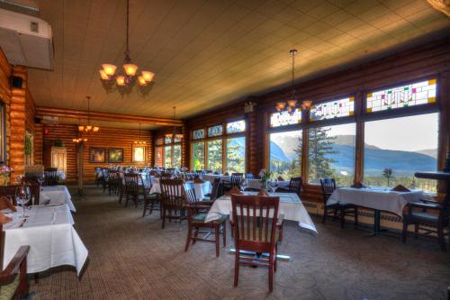 a dining room with tables and chairs and windows at Overlander Mountain Lodge in Jasper