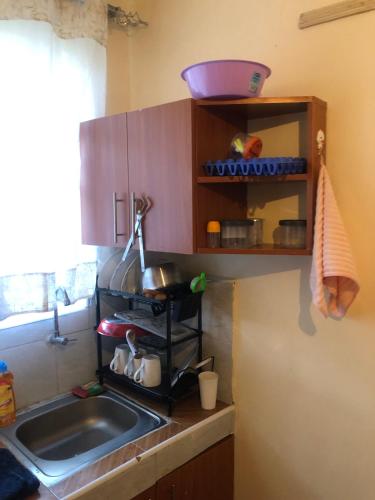 a kitchen counter with a sink and a window at Hornville suites in Ongata Rongai 