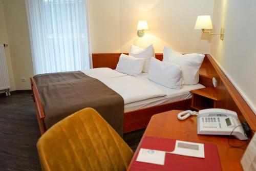 a hotel room with a bed and a telephone at Hotel Lorösch in Bad Orb