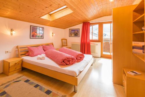 ein Schlafzimmer mit einem Bett mit rosa Kissen in der Unterkunft Appartement Stuibenfallblick in Umhausen