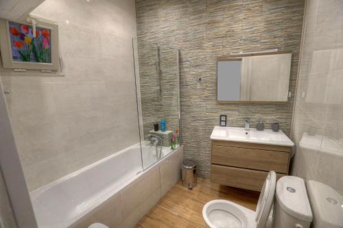 博索萊伊的住宿－Contrast LuxApart 3 min MC Casino，带浴缸、盥洗盆和卫生间的浴室