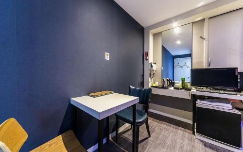 a room with a desk and a table with chairs at Donkey Hotel in Bucheon