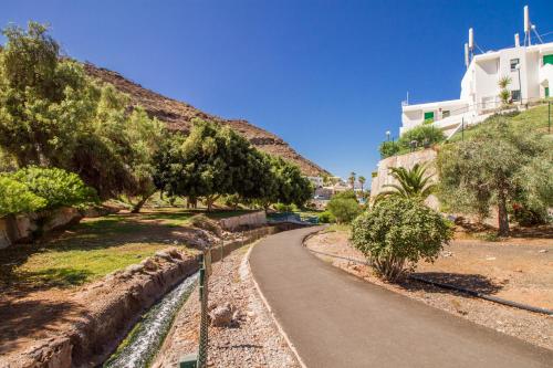 a winding road in a park with trees and a building at Granada II Apartments in Puerto Rico de Gran Canaria