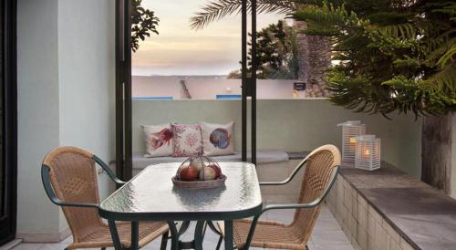 a table and chairs on a balcony with a view of the ocean at Minos Apartments & Studios in Sitia