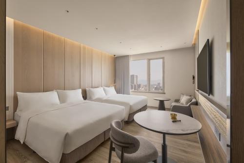 ein Hotelzimmer mit zwei Betten und einem Tisch in der Unterkunft Hotel UKETAMO in Taipeh