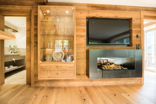 a living room with a fireplace and a tv at Pepi's Suites - Lechtal Apartments in Holzgau