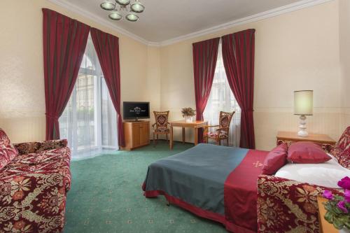 a hotel room with a bed and a table and chairs at Green Garden Hotel in Prague