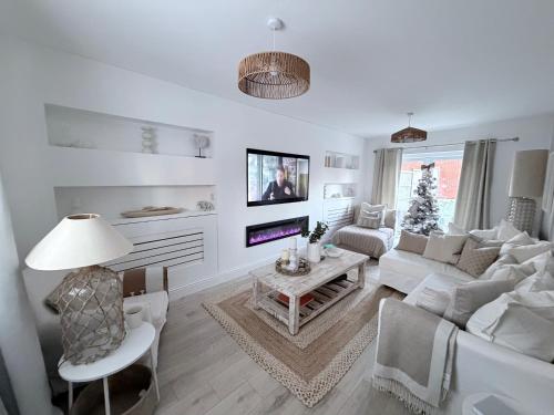 a white living room with a couch and a table at Southkey House in Repton