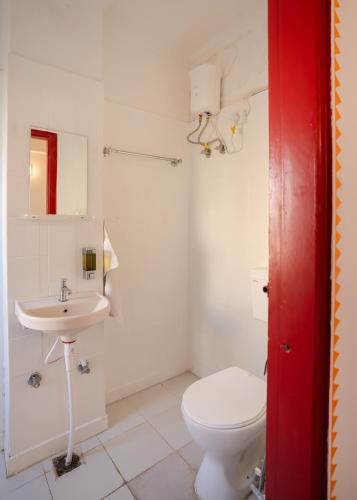 a white bathroom with a toilet and a sink at Hammock Hostels - Jaipur in Jaipur