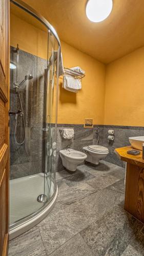a bathroom with two sinks and a shower and two toilets at Appartamento Montagnards in Morgex