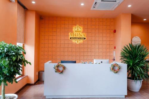 a reception desk in a room with a sign on the wall at Khách sạn Mona in Dĩ An