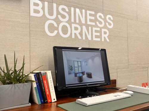 a computer monitor sitting on a desk with books at Sungsan Marina Hotel in Seogwipo
