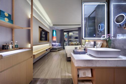 a bathroom with a sink and a large mirror at Guilin Yangshuo Shixi Landscape Hotel in Yangshuo