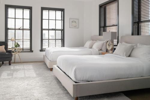 two beds in a white room with windows at Gorgeous Apartment 2-bedroom 2-bathroom in Los Angeles