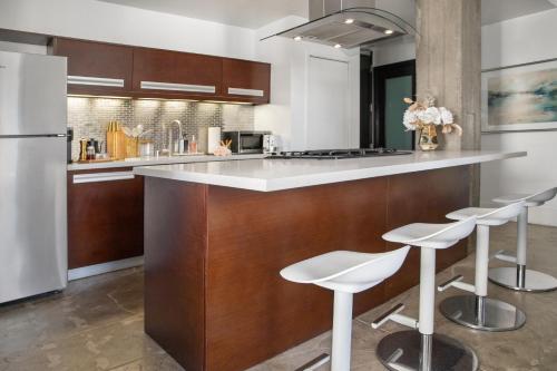 a kitchen with a white counter and stools at Gorgeous Apartment 2-bedroom 2-bathroom in Los Angeles
