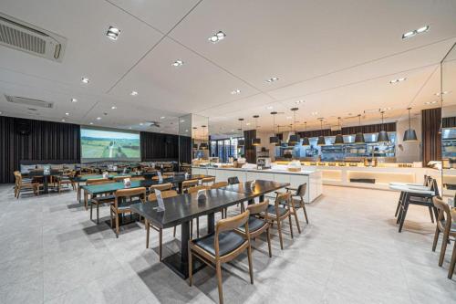 a restaurant with tables and chairs and a bar at Sungsan Marina Hotel in Seogwipo
