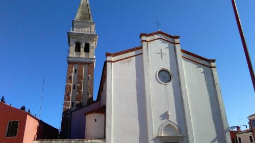 a church with a tall tower with a clock on it at L'Antico Lido Venice in Venice-Lido