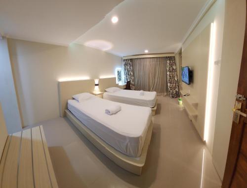 a hotel room with two beds and a television at Bali Balitung in Seminyak