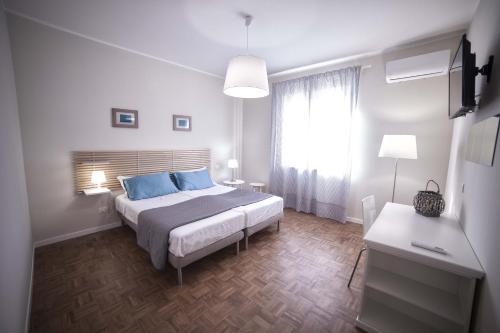 Un dormitorio con una cama con almohadas azules y una ventana en Home Scala dei Turchi B&B, en Realmonte
