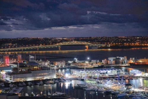 a view of a harbor at night with a bridge at Magnificent SkyTower, Sea, Habour View in CBD in Auckland
