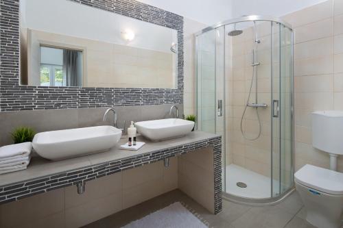 a bathroom with two sinks and a shower at Istrian Villa Happy House in Nedeščina