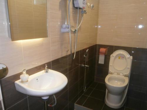 een badkamer met een wastafel en een toilet bij F.M GUESTHOUSE in Kampong Darat Tanah Puteh