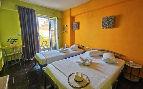 zwei Betten in einem Zimmer mit gelben Wänden in der Unterkunft Lilalo Ηotel in Paralia Katerinis