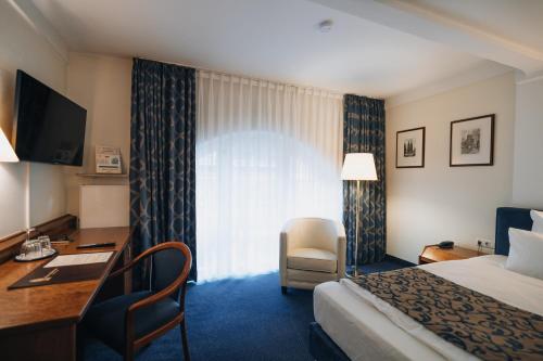 ein Hotelzimmer mit Bett und Schreibtisch in der Unterkunft Hotel Viktoria in Köln