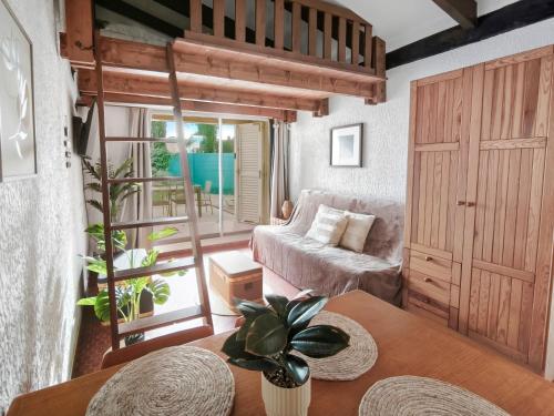 a living room with a couch and a table at Studio Cosy avec terrasse et parking privé in Cap d'Agde