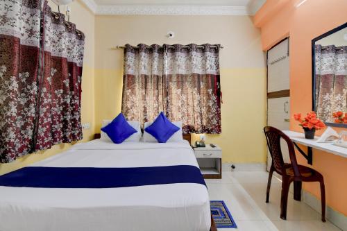 a bedroom with a bed with blue pillows and a desk at Avinaav Inn in New Town