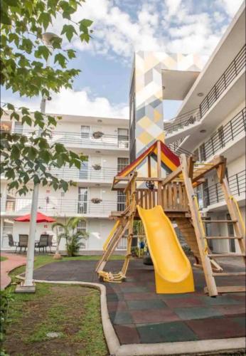 a playground with a slide in front of a building at Family apartment next to Arena GDL and Zoo in Guadalajara
