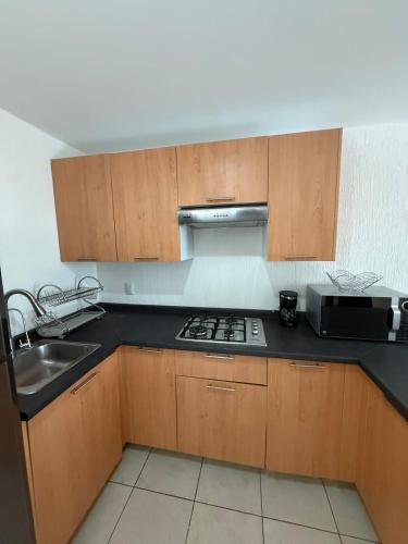 a kitchen with a sink and a stove top oven at Family apartment next to Arena GDL and Zoo in Guadalajara