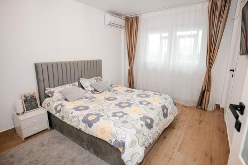 a bedroom with a bed with a comforter on it at Sunset Studio Valcea in Râmnicu Vâlcea