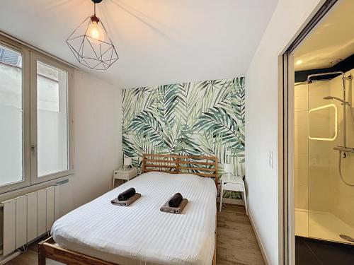 a bedroom with a bed with a tropical wallpaper at Le Forum - Appartement rare - Parking privé - Centre - Reims in Reims