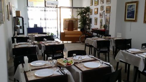 une salle à manger avec des tables et des chaises blanches dans l'établissement Terra del Sole Vittoria, à Vittoria