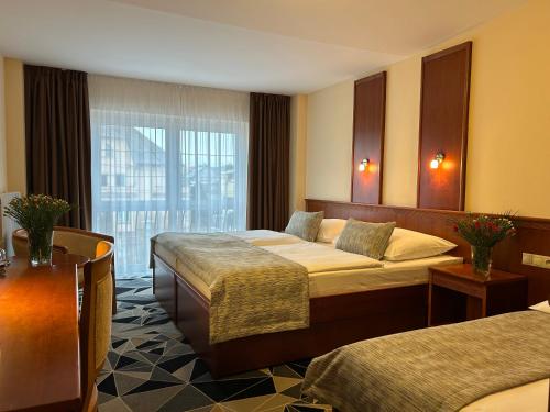 a hotel room with two beds and a window at PRIMAVERA Hotel & Congress centre in Pilsen