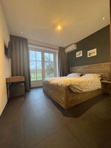 a bedroom with a large bed and a large window at Jaegershoes in Belfeld