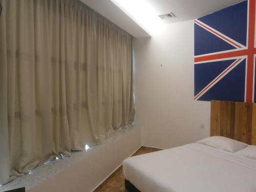 een slaapkamer met een Britse vlag aan de muur bij F.M GUESTHOUSE in Kampong Darat Tanah Puteh