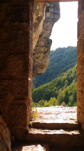 a window in a stone wall with a view of a mountain at Le Pietre Ricce B&B in Roccamontepiano