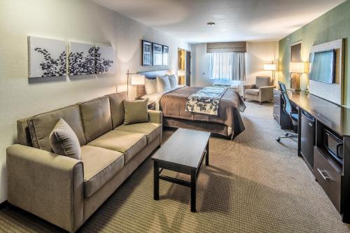 a hotel room with a bed and a couch at Sleep Inn & Suites East Syracuse in East Syracuse