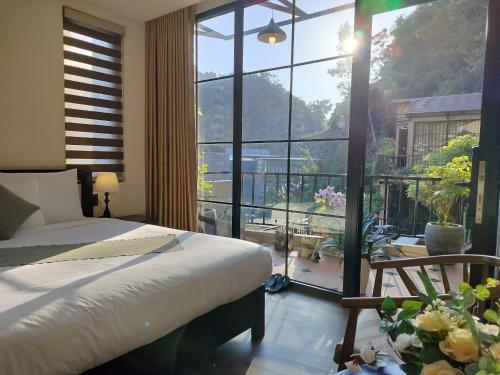 a bedroom with a bed and a large window at Catba Garden Camellia in Cat Ba