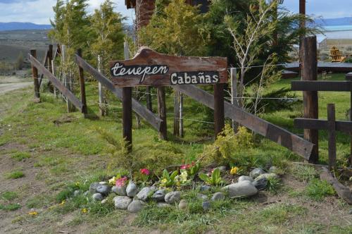 a sign on a fence with a bunch of flowers at Cabañas Teuepen in El Calafate