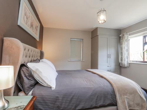 a bedroom with a bed and a window at Baywood Cottage in Keighley