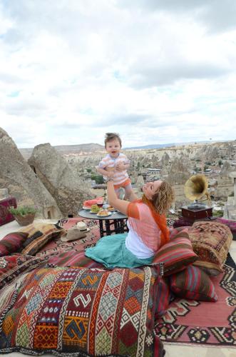 a woman holding a child on top of a table at Harman Cave Hotel in Goreme