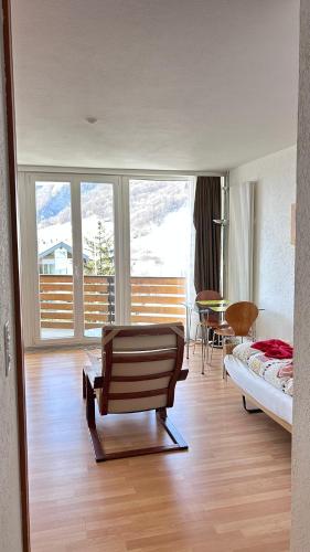 a bedroom with a bed and a chair and a table at Matterhof in Leukerbad