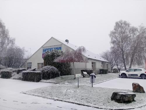 ein Gebäude mit einer Parkuhr im Schnee in der Unterkunft Hôtel Inn Design Laval in Laval