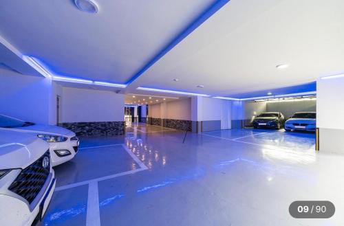 two cars parked in a garage with blue lights at Hotel Social Stay in Pocheon