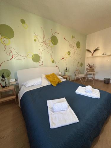 a bedroom with a blue bed with towels on it at At Home Bed and Breakfast in Lucca